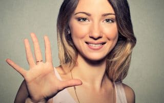 Smiling woman holding up five fingers