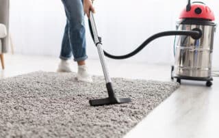 Woman vacuuming a rug in a living room